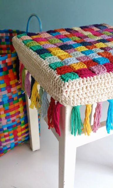 a usual stool renovated with a bright crocheted cover with tassels is a very cozy and lovely idea that will make your piece softer