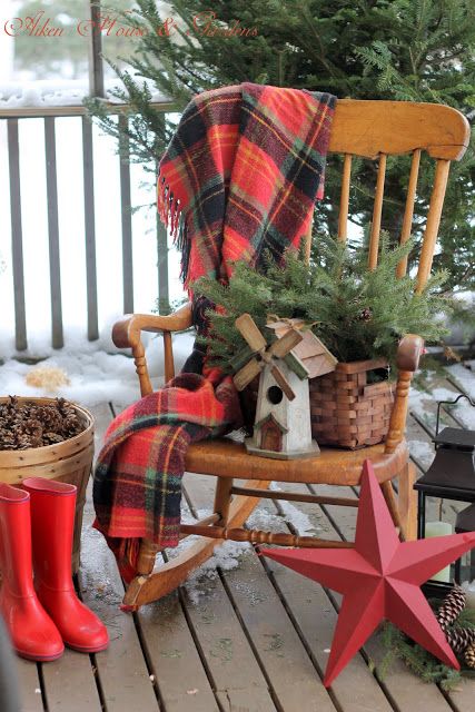 a vintage rocker, a plaid blanket, a basket with fir branches, a mini mill, a red star and boots for a rustic feel outdoors