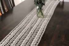 an elegant and airy white crochet table runner is a chic idea for a modern or shabby chic space, it may add charm to a rustic one, too