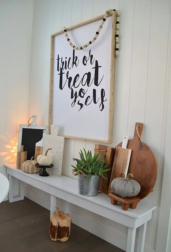 an oversized Halloween sign in a frame and some fabric pumpkins and cutting boards on display
