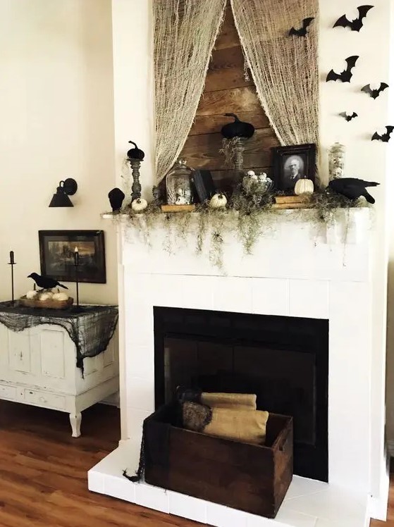 chic vintage fireplace styling with greenery, pumpkins, bats, portraits, books and some spider web here and there