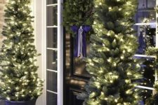 evergreen garlands with lights, Christmas trees with lights in pots and gift boxes for a cozy holiday feel