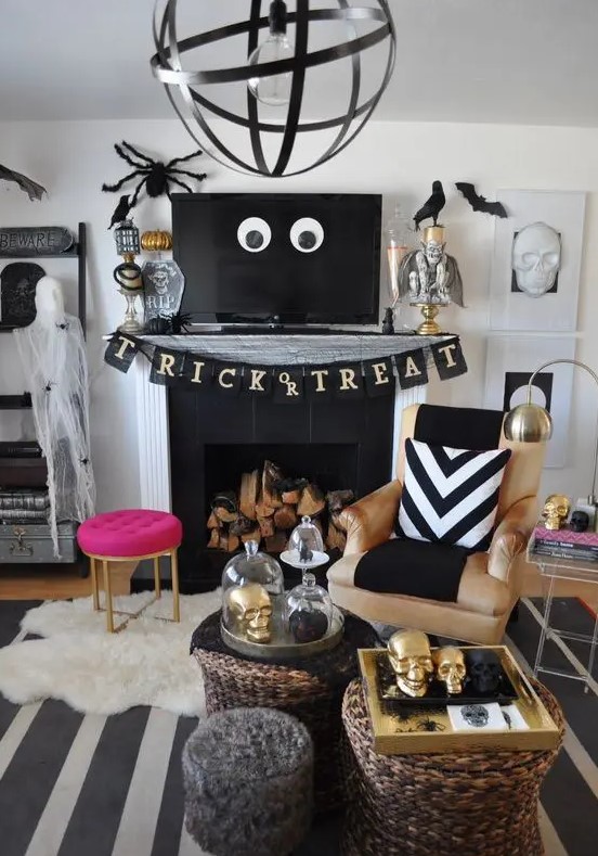 glam Halloween decor with a black banner, spiders, bats, gold skulls and a hot pink stool