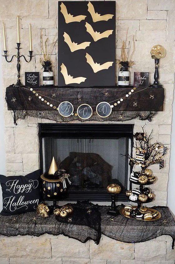 glam black and gold Halloween decor - an artwork with gold bats, a gold garland, gold candles, pumpkins and black mesh