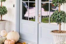 heirloom pumpkins, greenery in pots and a mat for natural Thanksgiving decor