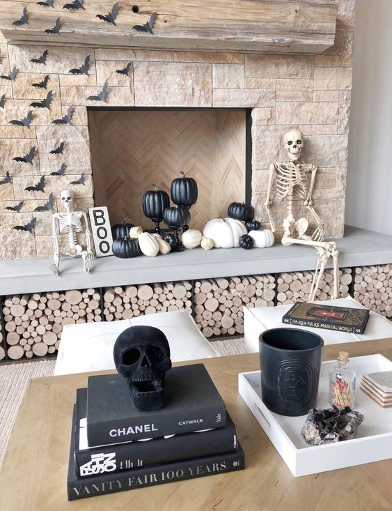modern Halloween styling with a couple of skeletons and skulls, black and white pumpkins, paper bats and a sign