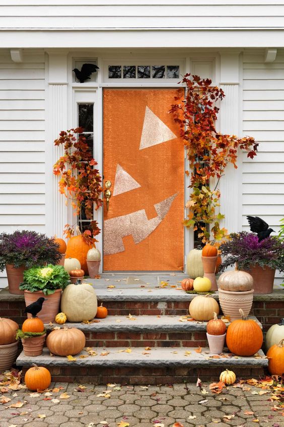 natural pumpkins, spray painted or not, fall leaves and a front door styled as a jack-o-lantern for a bright Halloween porch