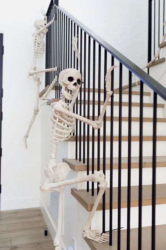 skeletons climbing up the railing are a fun and very easy idea to style your home for Halloween and you can realize that very quickly