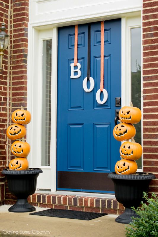 stacked jack-o-lanterns and letters hanging on the door instead of a usual Halloween wreath are a great idea to go for