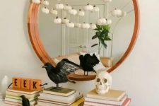 stylish minimalist Halloween decor with blackbirds, a skull and a garland of mini white pumpkins is very chic and cool