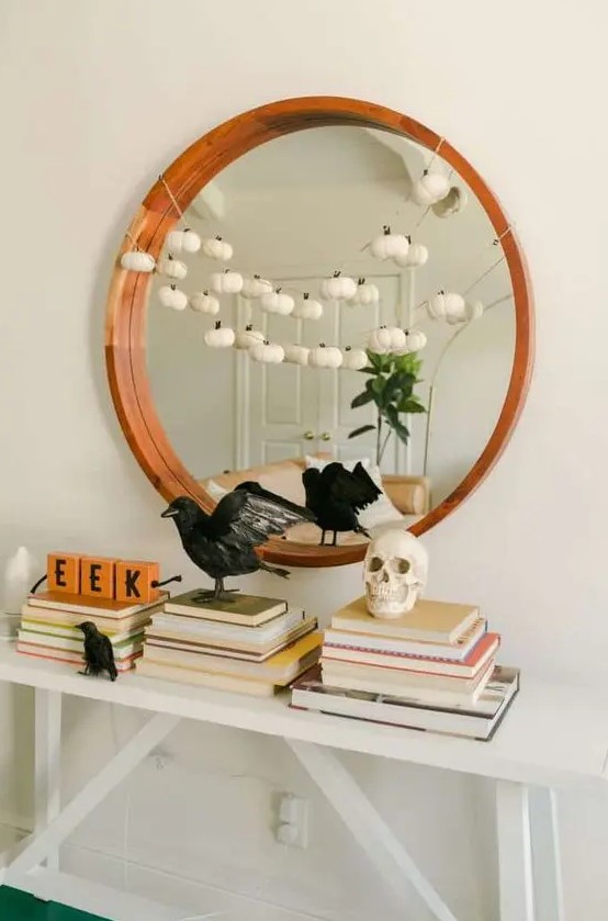 stylish minimalist Halloween decor with blackbirds, a skull and a garland of mini white pumpkins is very chic and cool
