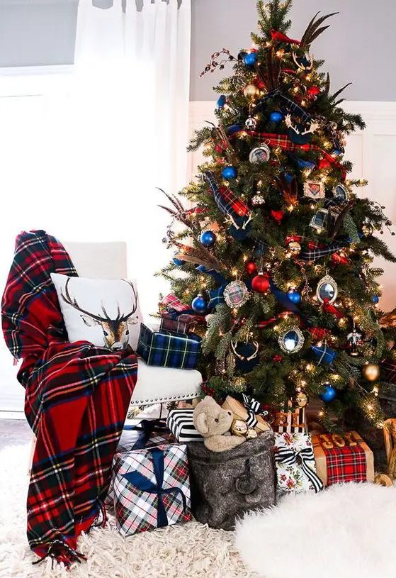 a Christmas tree decorated in blue and red, with blue and red ribbons and ornaments and matching pieces around