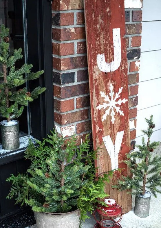 a JOY sign, mini Christmas trees in buckets, a red vintage lantern for a rustic vintage feel in the space