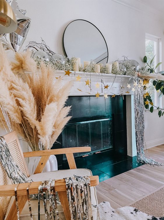 a NYE mantel with baby's breath, silver tinsel, gold stars, pampas grass and silver balloons is a cool idea