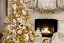 a beautiful Christmas tree fully covered with white and gold ornaments, faux white and gold blooms, icy and gold branches