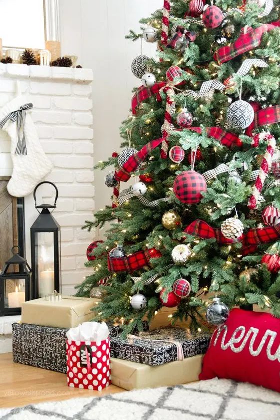 a beautiful Christmas tree with oversized red plaid ornaments and ribbons, shiny gold and silver ones and some vintage bells is amazing