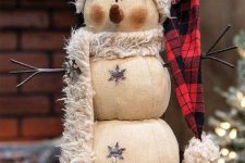 a beautiful snowman decoration of fabric, with a faux fur scarf and a plaid hat is a very chic vintage-inspired idea