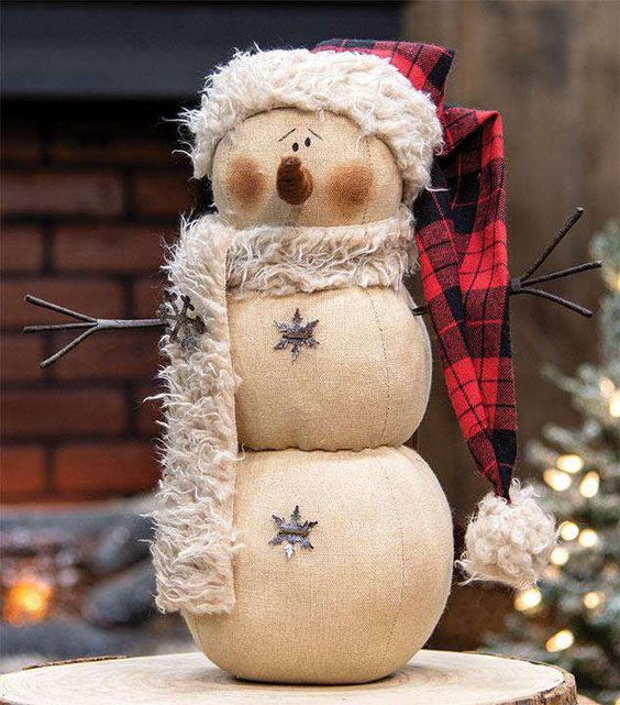a beautiful snowman decoration of fabric, with a faux fur scarf and a plaid hat is a very chic vintage inspired idea