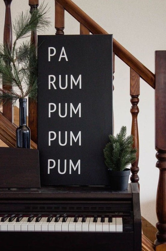 a black and white Christmas sign and evergreens in pots and bottles for minimalist Christmas decor