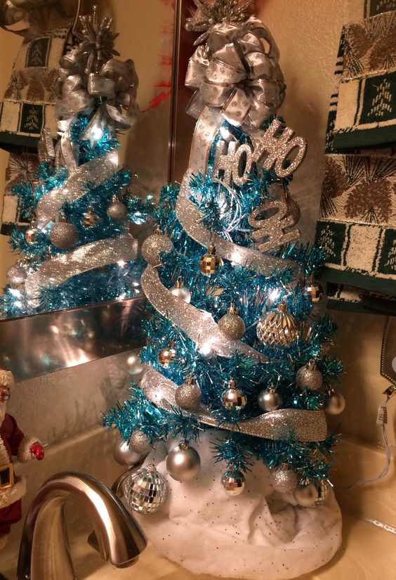 a blue Christmas tree with silver and glitter ornaments, glitter ribbons and a bow on top plus letters is amazing as an additional one