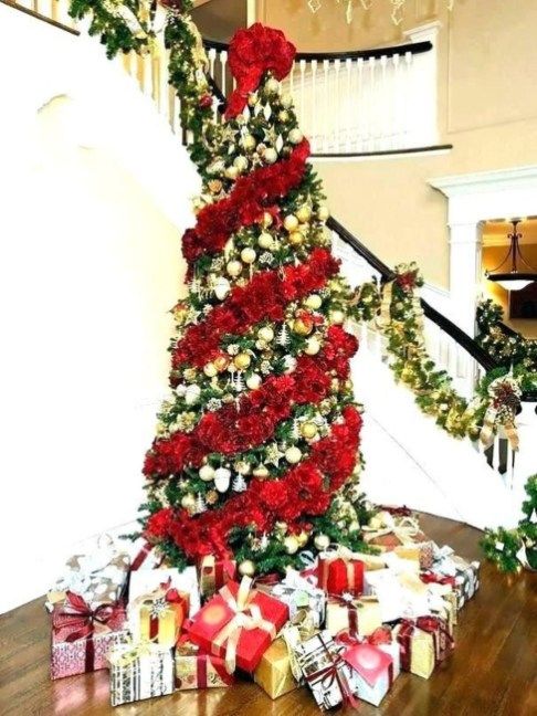 a bold Christmas tree with gold ornaments and a fluffy red garland plus a large red bow on top