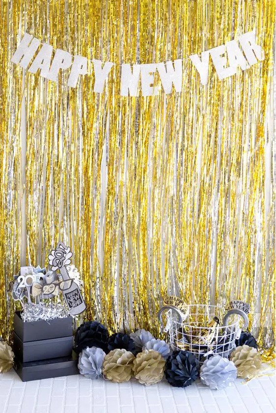 a bold photo booth in black, gold and silver with fringe and props