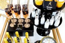 a brass bar cart with glitter bottles, fringe cupcake toppers and a glitter clock is a gorgeous idea for a NYE party
