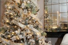 a breathtaking flocked Christmas tree with pearly and gold ornaments, gold plaid ribbon, lights and berries