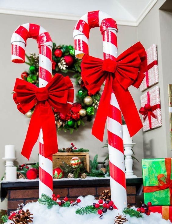 a bright Christmas decoration of candy canes with red bows, faux snow, berries and pinecones is amazing and easy to recreate