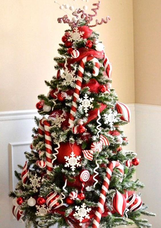 a bright and chic Christmas tree with candy canes, red ornaments, snowflakes, twigs and berries is amazing