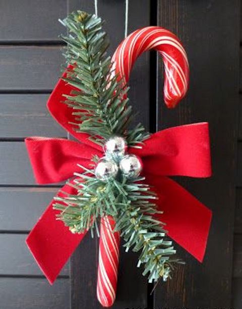 a candy cane with a red bow, fir twigs and bells is a lovely Christmas decoration or ornament