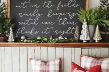 a chalkboard Christmas sign with white calligraphy and evergreens on top is a lovely idea