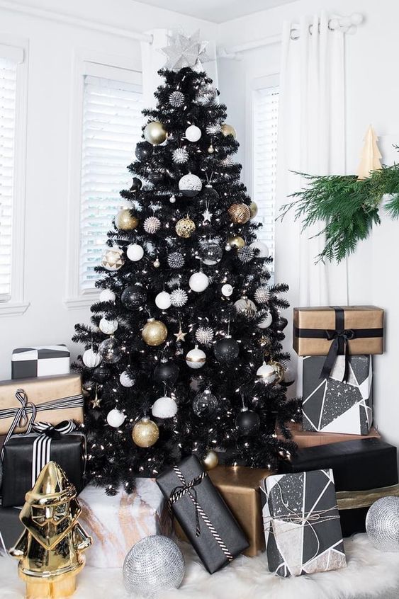 a classy Christmas tree in black with white, black and gold ornaments and stars and lights is all glam and chic