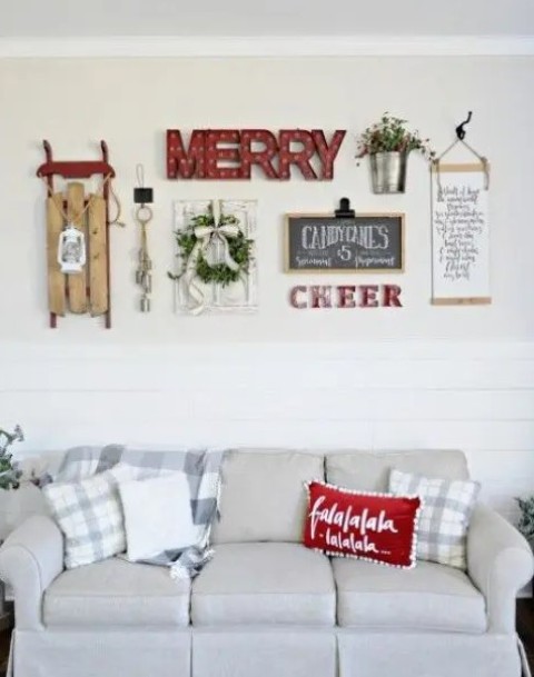 a cozy gallery wall with marquee lights, signs, a wreath, a lantern, a sleigh and some greenery