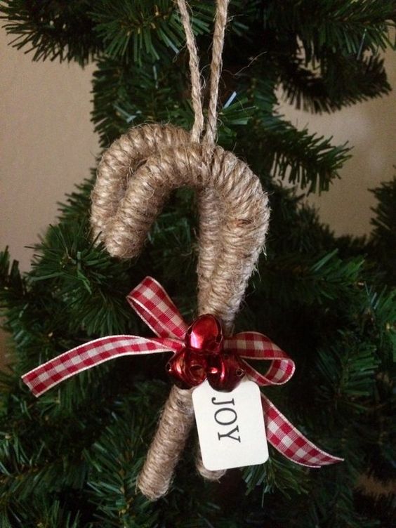 a cozy rustic Christmas ornament - a twine wrapped candy cane with red bells and a plaid bow is a lovely idea