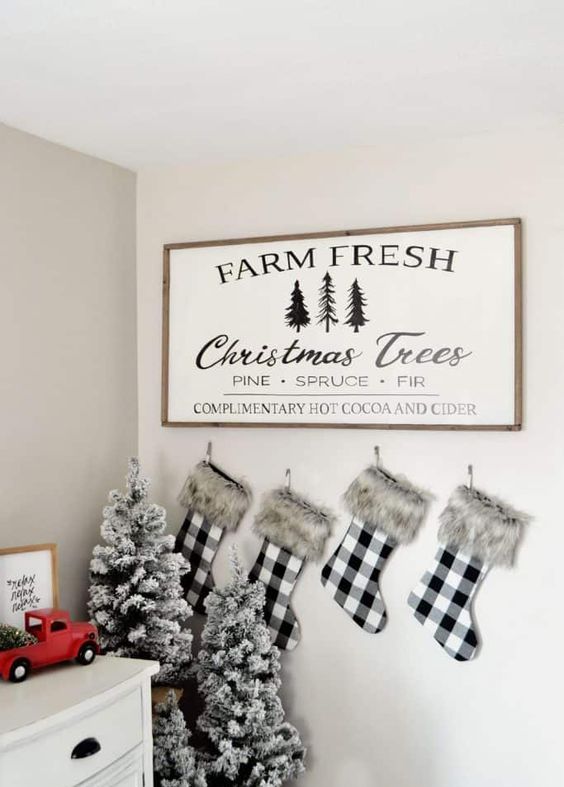 a farmhouse Christmas sign with a stained frame and black printing is a cool and chic idea for any farmhouse home