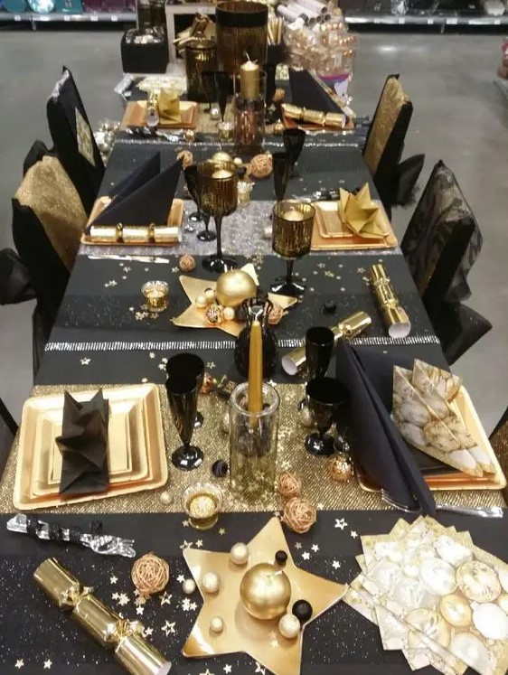 a fun black and gold tablescape with stars, stripes and candles is amazing for a New Year's Eve