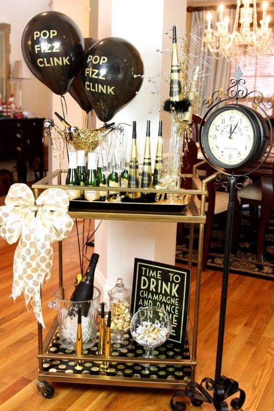 a gold and black bar cart with balloons, a polka dot bow and polka dot paper is a great idea for a NYE party