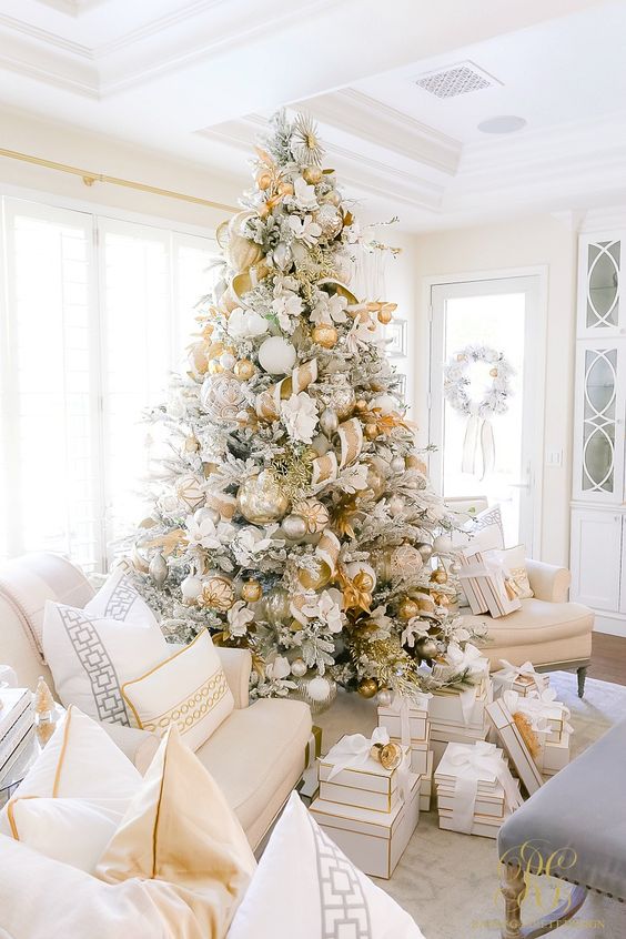 a jaw-dropping Christmas tree with oversized gold, silver and white ornaments, gold and white ribbons and white fabric blooms