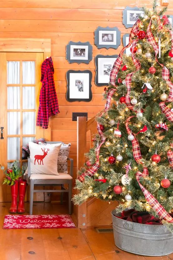 a large Christmas tree decorated with red and white ornaments and plaid ribbons is a bold and traditional idea for the holidays