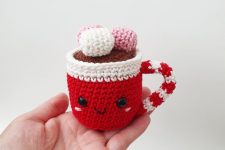 a little red and white knit mug with marshmallows on top is a cute Christmas ornament or decoration you can DIY