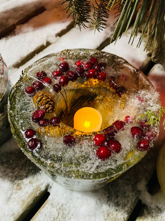 a lovely Christmas ice lantern with evergreens, cranberries and a pinecone is a cool way to illuminate your outdoor space