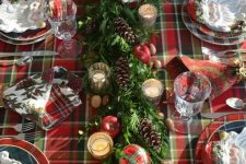 a plaid tablecloth, plaid napkins and plates and even plaid ornaments refreshed with evergreens
