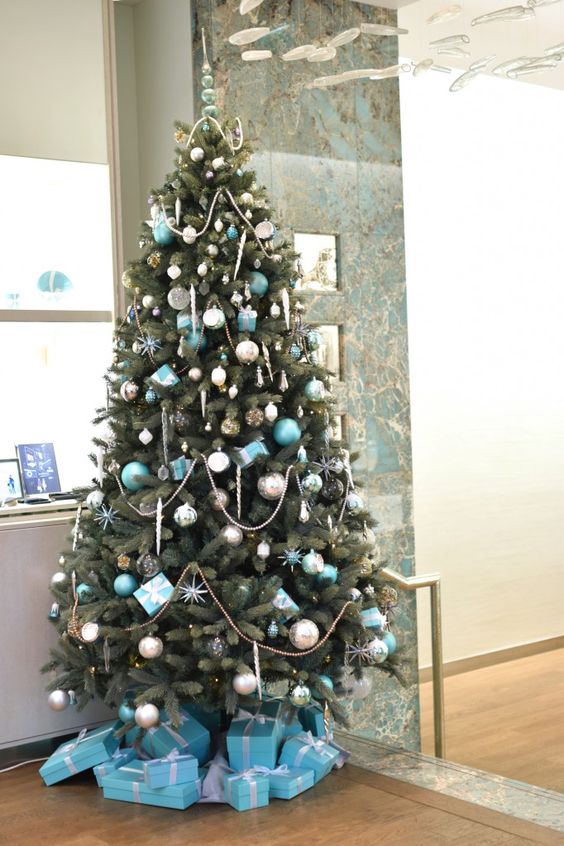 a pretty Christmas tree with silver and tiffany blue ornaments, stars, lights, beads and gifts is a very chic and glam idea