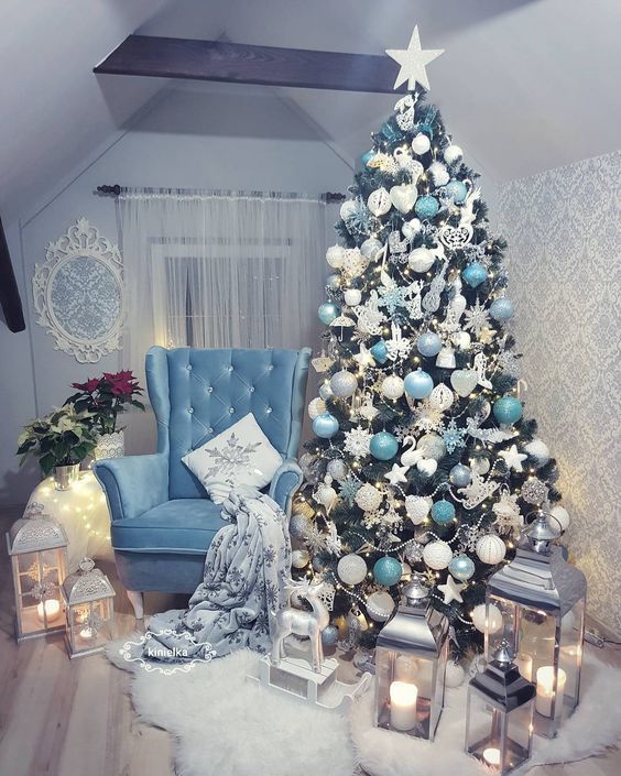a pretty and glam Christmas tree with white, silver, tiffany blue ornaments and beads and a star topper is chic and cool