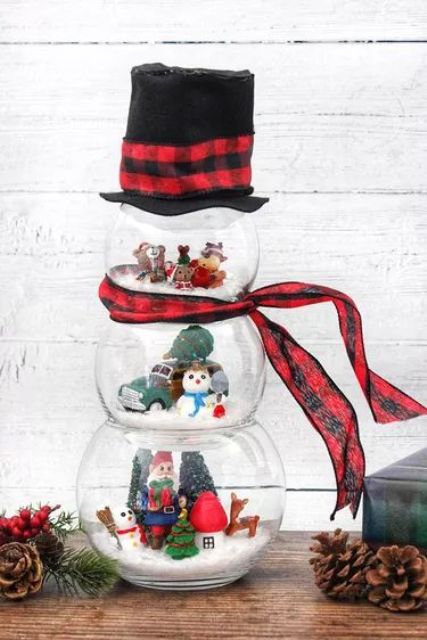 a pretty snowman of fish bowls with mini toy scenes inside, with a plaid scarf and a top hat is a lovely decoration for winter