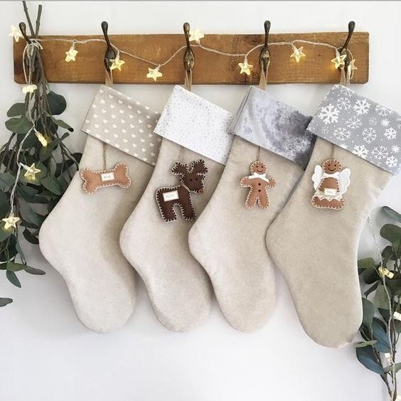 a rack with a star light garland, neutral stockings and felt tags inspired by Christmas plus greenery is a gorgeous idea for holidays