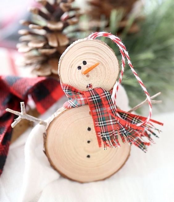 a rustic snowman Christmas ornament with a plywood scarf and yarn is a cool decoration you can DIY