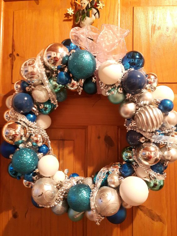 a shiny Christmas wreath of tiffany blue, navy, white and silver ornaments and ribbons is a pretty decoration to rock