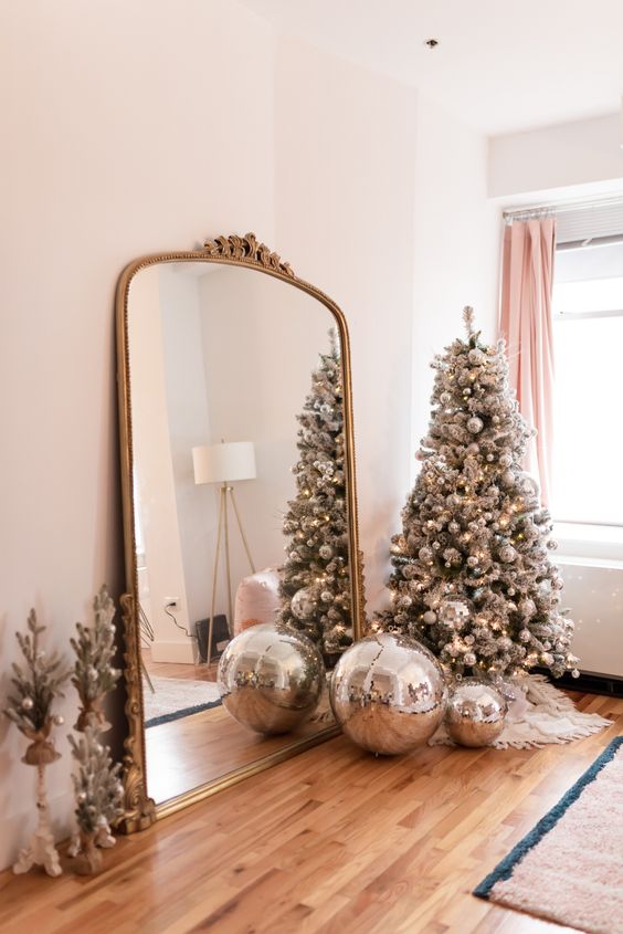 a silver Christmas tree fully decorated with silver disco balls is a super cool and fresh decor idea for a NYE party